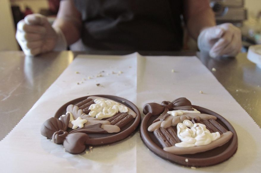 In this Thursday, Dec. 21, 2017 photo, two finished chocolate nativity scenes sit in front of Jennie Hales in the Truffle Cottage's kitchen, in Pleasant Grove, Utah. (Evan Cobb /The Daily Herald via AP)