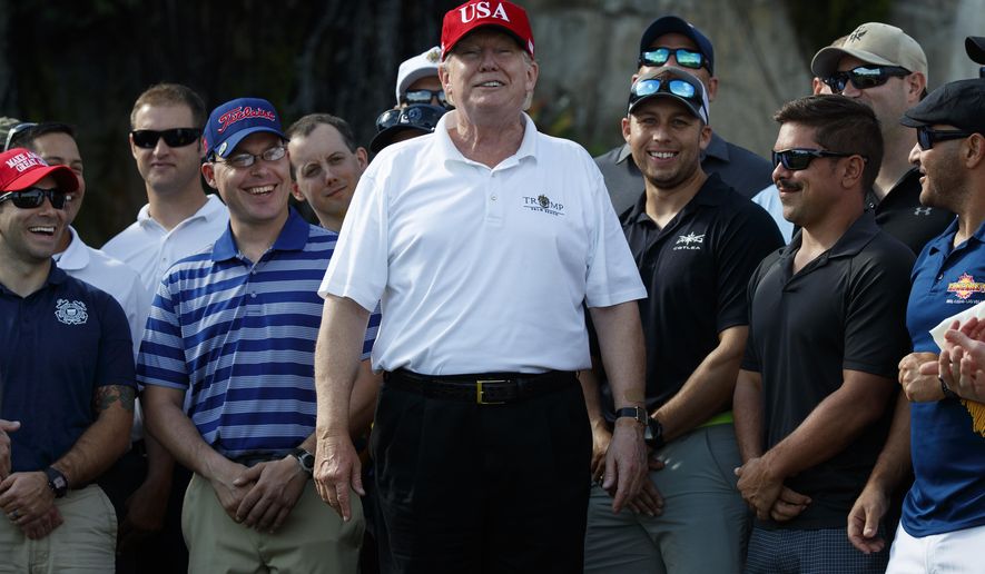 President Donald Trump smiles as he meets with members of the U.S. Coast Guard, who he invited to play golf, at Trump International Golf Club, Friday, Dec. 29, 2017, in West Palm Beach, Fla. (AP Photo/Evan Vucci)