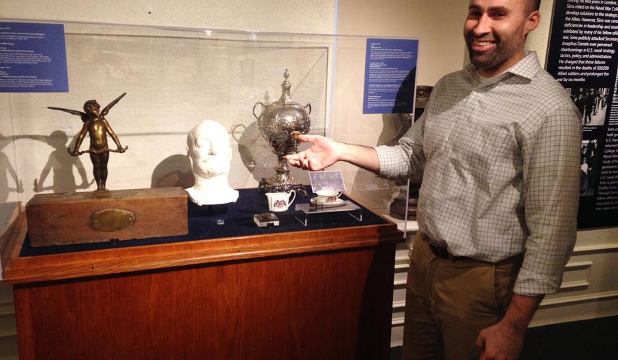 In this Monday, Dec. 18, 2017 photo, U.S. Naval War College Museum Curator Rob Doane points to artifacts donated by the family of Navy Adm. William S. Sims for the museum's new exhibit about World War I in Newport, R.I. Sims commanded U.S. naval forces in Europe during the war. The artifacts include Sims' death mask from 1936. (AP Photo/Jennifer McDermott)