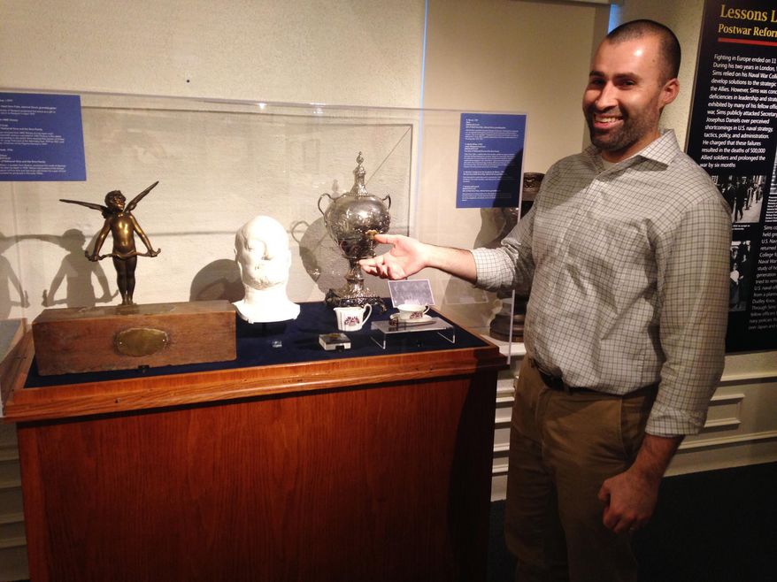 In this Monday, Dec. 18, 2017 photo, U.S. Naval War College Museum Curator Rob Doane points to artifacts donated by the family of Navy Adm. William S. Sims for the museum's new exhibit about World War I in Newport, R.I. Sims commanded U.S. naval forces in Europe during the war. The artifacts include Sims' death mask from 1936. (AP Photo/Jennifer McDermott)