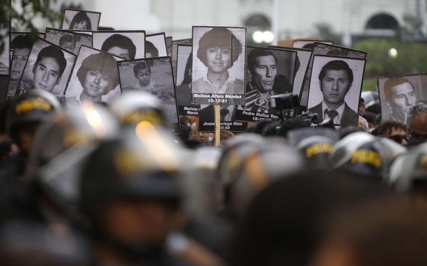 Demonstrators march during a protest against the pardon of former President Alberto Fujimori holding photographs of people who disappeared during his government, in Lima, Peru, Thursday, Dec. 28, 2017. Peru's President Pedro Pablo Kuczynski granted a medical pardon to the former strongman Fujimori who was serving a 25-year sentence for human rights abuses, corruption and the sanctioning of death squads. (AP Photo/Martin Mejia)