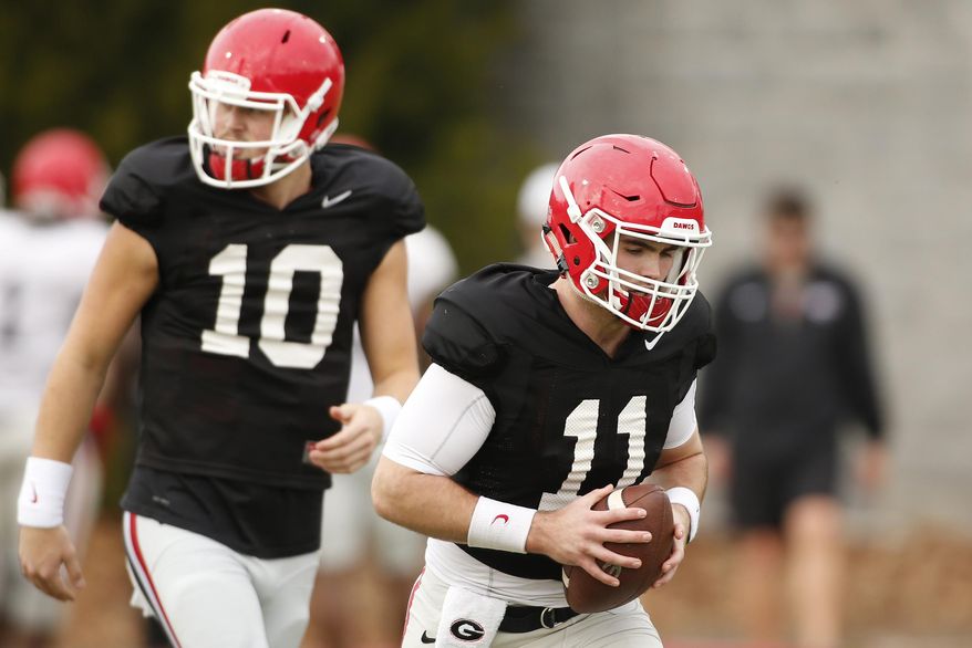 This Dec. 18, 2017 file photo shows Georgia NCAA college football quarterbacks Jake Fromm (11) and Jacob Eason (10) running a drill during a team practice in Athens, Ga. Eason lost his starting job for Georgia after he was injured in the first game of the season. The former five-star recruit has embraced his role as backup to freshman star Jake Fromm, but Eason acknowledges the difficulty of losing his job through no fault of his own. Georgia faces Oklahoma in the Rose Bowl on Jan. 1, 2018. (Joshua L. Jones/Athens Banner-Herald via AP)