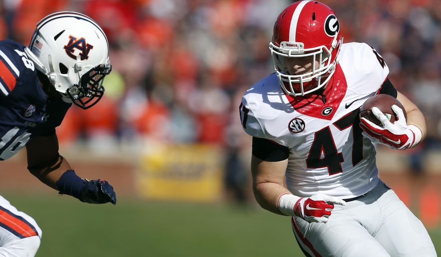 FILE - In this Nov. 14, 2015, file photo, Georgia fullback Christian Payne (47) carries the ball as Auburn defensive back Carlton Davis (18) closes in for a tackle during during the first quarter of an NCAA football game in Auburn, Ala. No. 2 Oklahoma and No. 3 Georgia meet for the first time Monday, Jan. 1, 2018, at the Rose Bowl in a College Football Playoff semifinal that features two very different ways of playing offense. (AP Photo/Butch Dill, File)