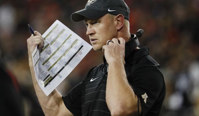 FILE - In this Oct. 7, 2017, file photo, UCF head coach Scott Frost works the sidelines in the first half of an NCAA college football game against Cincinnati, in Cincinnati. No. 10 Central Florida will by playing for a perfect season and respect for the team and its conference, when it faces No. 7 Auburn in the Peach Bowl on Monday, Jan 1, 2018.  (AP Photo/John Minchillo, File)