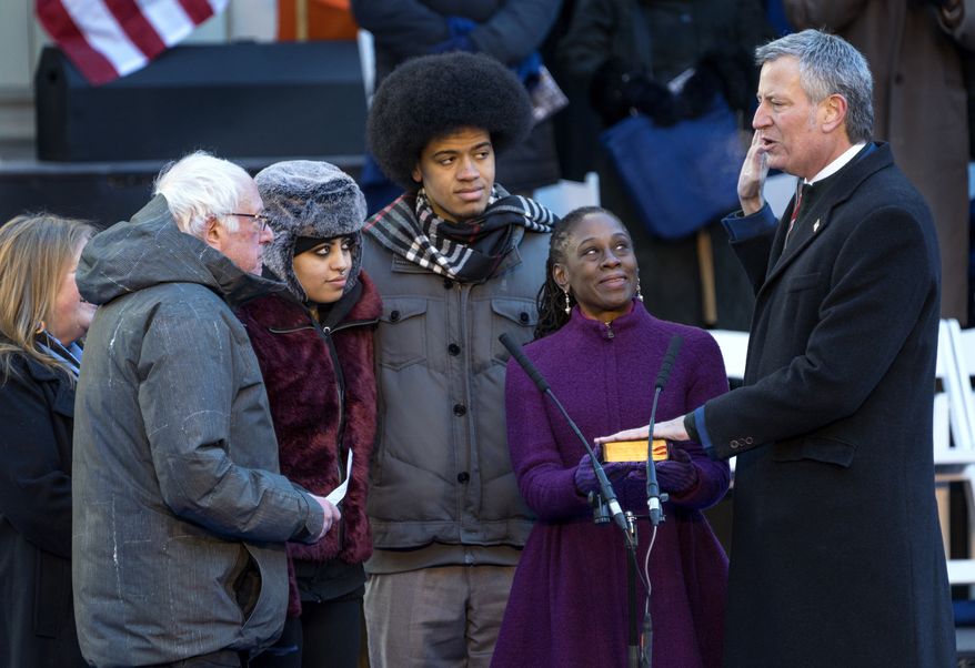 U.S. Sen. Bernie Sanders, I-Vt., left, swears in New York Mayor Bill de Blasio for a second term as mayor at City Hall in New York, Monday, Jan. 1, 2018. With De Blasio, second from left, are his daughter Chiara, son Dante, and wife, Chirlane McCray. (AP Photo/Craig Ruttle)