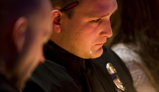 Officer Sean R. Bigler reacts during a candlelight vigil at Mission Hills Church on Monday, Jan. 1, 2018, for Deputy Zackari Parrish, 29, in Littleton, Colorado. A man who shot and killed the Colorado deputy and wounded several others along with a few civilians was an attorney and an Iraq war veteran who had posted videos online in recent months criticizing professors and law enforcement officials, authorities said Monday. (Dougal Brownlie/The Gazette via AP)