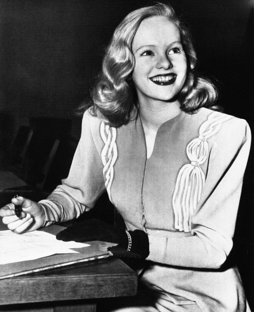 FILE - In this Dec. 26, 1945, file photo, actress Peggy Cummins, 20, smiles in Superior Court, in Los Angeles, after her contract with Twentieth Century-Fox Studio had been approved. Cummins, who gave an indelible performance as the lethal, beret-wearing robber in the noir classic "Gun Crazy," has died. Cummins, who retired from acting in the early 1960s, died Friday, Dec. 29, 2017, in London at age 92. (AP Photo/File)