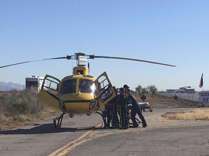First responders load an injured passenger onto a helicopter for transportation to a hospital Friday, Dec. 29, 2017 at Rooster Cogburn Ostrich Ranch in Picacho, Ariz. Twelve people were injured when the tour truck they were riding in rolled over. (Maria Vasquez/Casa Grande Dispatch via The AP)