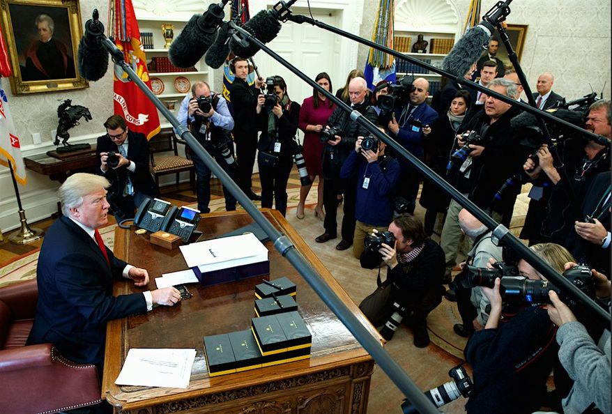 President Trump has a moment with reporters and photographers in the Oval Office of the White House. (AP Photo/Evan Vucci) (Associated Press) ** FILE **