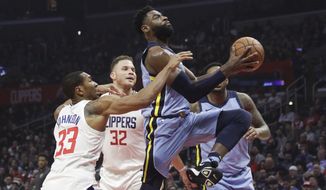 Memphis Grizzlies&#39; Tyreke Evans, right, goes up for a basket past Los Angeles Clippers&#39; Wesley Johnson, left, and Blake Griffin during the first half of an NBA basketball game Tuesday, Jan. 2, 2018, in Los Angeles. (AP Photo/Jae C. Hong)