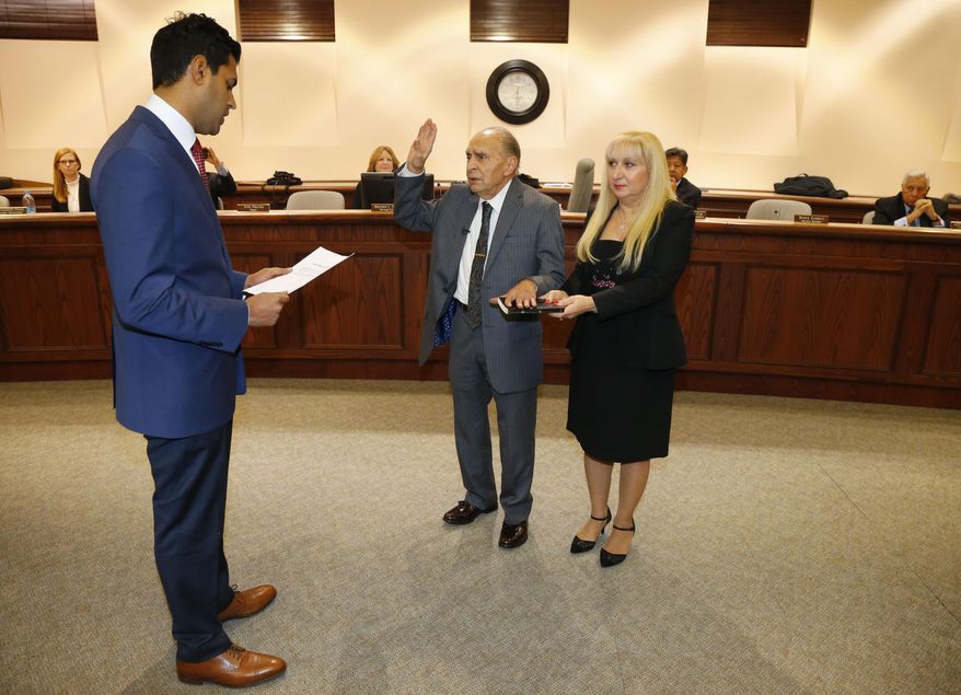 Nintey-three year-old WWII Veteran Vito Perillo, center, is sworn in as mayor of Tinton Falls, N.J., by Senator Vin Gopal, left, during ceremony at Borough Hall, Tinton Falls,NJ. Anna Mae Perillo was at the side of Perillo during ceremony Tuesday, Jan. 2, 2018. (Noah K. Murray /The Asbury Park Press via AP)