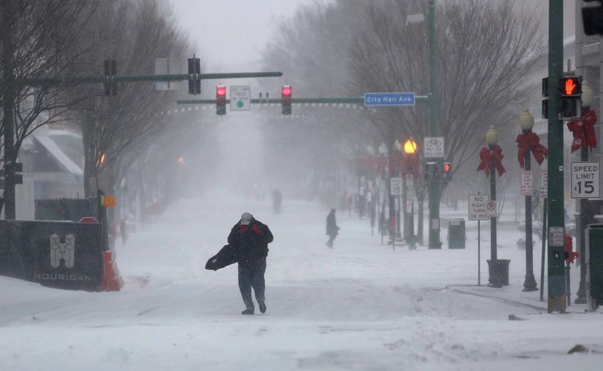 Rick Bailey walks through the wind and snow on his way to work in Norfolk, Virginia, on Thursday. Most local areas were expected to see overnight low temperatures of only 6 degrees Fahrenheit. (Associated Press photographs)