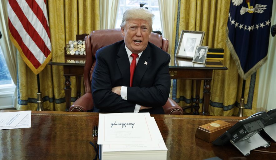 In this Dec. 22, 2017, file photo, President Donald Trump speaks with reporters after signing the tax bill and continuing resolution to fund the government, in the Oval Office of the White House in Washington. (AP Photo/Evan Vucci, File)