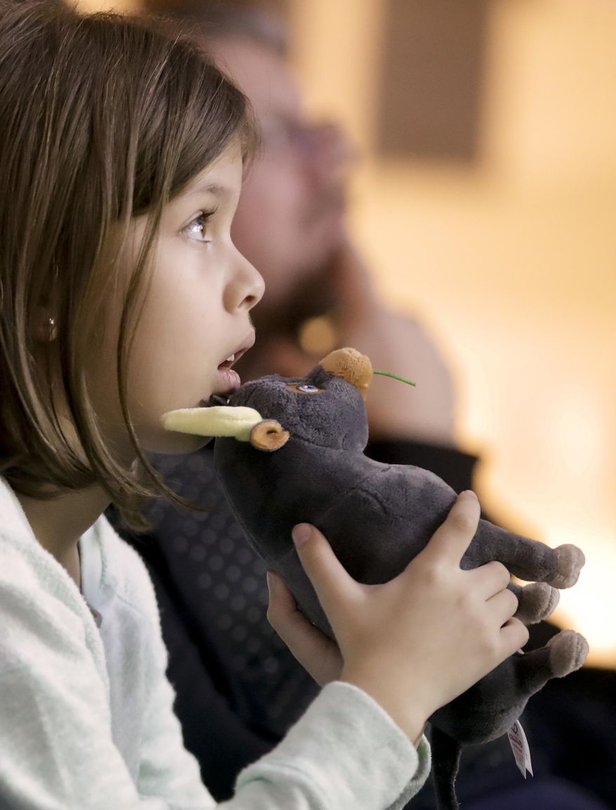 In this Tuesday, Dec. 19, 2017 photo, Haley Jay, 8, watches "Ferdinand" at Children's Hospital Orange County in Orange, Calif. Far away from the starry happenings Sunday, Jan. 7, 2018, around the Golden Globe Awards, this recent screening of “Ferdinand” at a local children’s hospital is among hundreds each year made possible by the profitability of the annual awards show. The Hollywood Foreign Press Association has been sharing spoils from the Globes’ international broadcast with arts-oriented nonprofits for 30 years. (AP Photo/Chris Carlson)