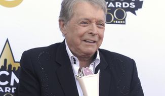 FILE - In this April 19, 2015 file photo, Mickey Gilley poses with the triple crown award on the red carpet at the 50th annual Academy of Country Music Awards at AT&amp;amp;T Stadium in Arlington, Texas. Country music artist Gilley and his son were injured in a car accident in Texas, but both are recovering after minor injuries. A statement from Gilley&#39;s publicist on Thursday, Jan. 4, 2018, said the two were injured Wednesday when their car rolled over. (Photo by Jack Plunkett/Invision/AP, File)