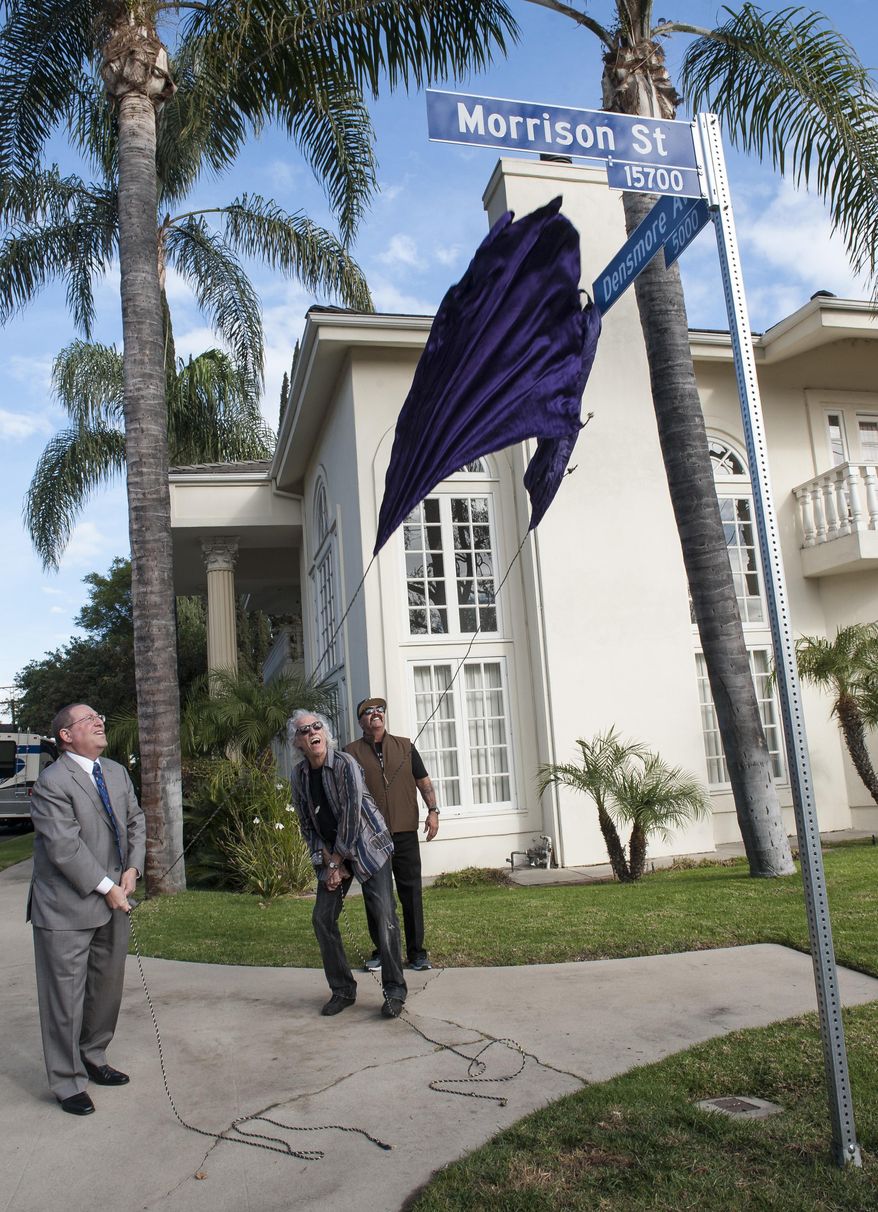 John Densmore and Los Angeles City Councilmember Paul Koretz, left, unveil an intersecting street signs for Morrison Street and Densmore Avenue in Encino, in honor of founding band members Jim Morrison and John Densmore during the second annual "Day Of The Doors" event in Encino on Thursday, Jan. 4, 2018. (Ed Crisostomo/Los Angeles Daily News via AP)