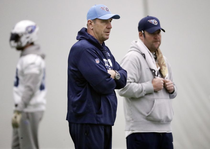 Tennessee Titans head coach Mike Mularkey, center, and general manager Jon Robinson watch during an NFL football practice Thursday, Jan. 4, 2018, in Nashville, Tenn. The Titans are scheduled to play the Kansas City Chiefs Saturday in an AFC wild-card playoff game. (AP Photo/Mark Humphrey)