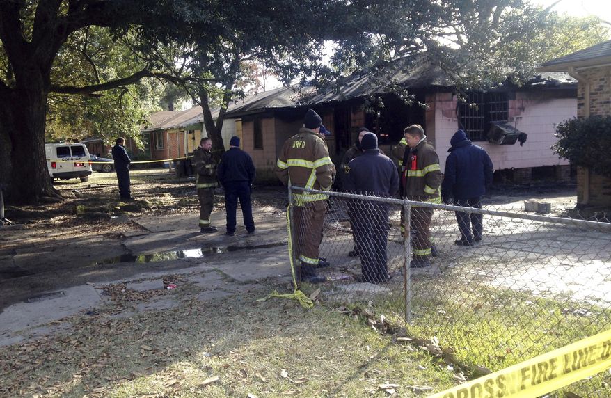 Emergency officials work the scene of a fatal fire in Baton Rouge on Friday, Jan. 5, 2018. Authorities say some have died and others were injured during the early morning house fire. Officials had not yet determined the cause. (AP Photo/Mike Kunzelman)