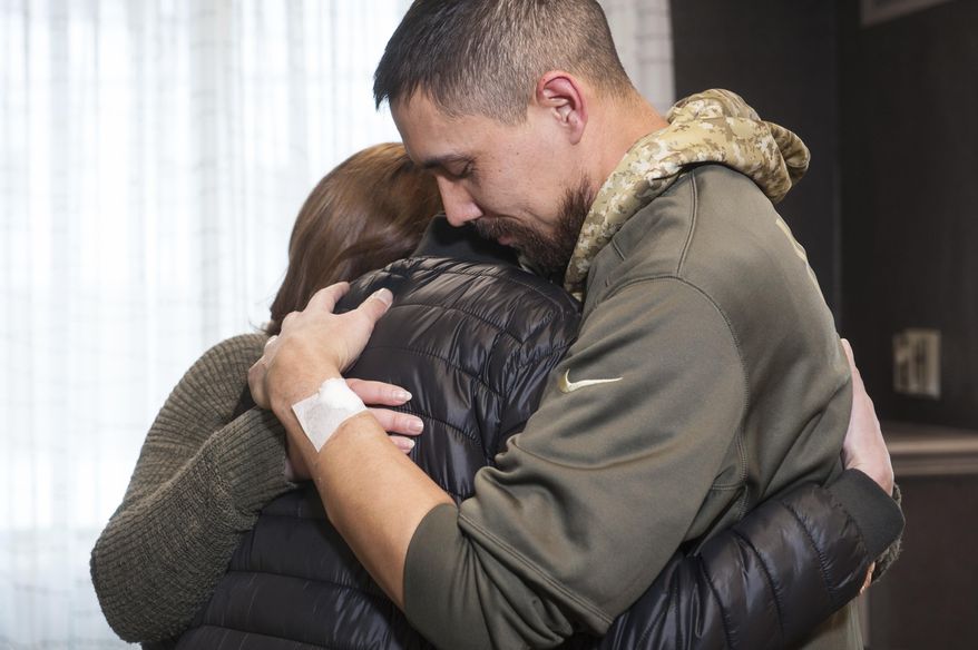 Erin Bond, back, 33, of Apple Valley, Minn., and her husband, John, right, 35, go in for a group hug with Olga Kemaeva, 34, the widow of Russian tourist Anton Kemaev, as they meet for the first time at the Residence Inn by Marriott on Thursday, Jan. 4, 2017, in North Oakland neighborhood of Pittsburgh. Mr. Bond believes he received Kemaev's kidney in a transplant operation he is currently recovering from. His family found out the donor was a 35-year-old Russian who had died from a gunshot wound and Googled the information, finding Kemaev's story in recent news. (Stephanie Strasburg/Pittsburgh Post-Gazette via AP)