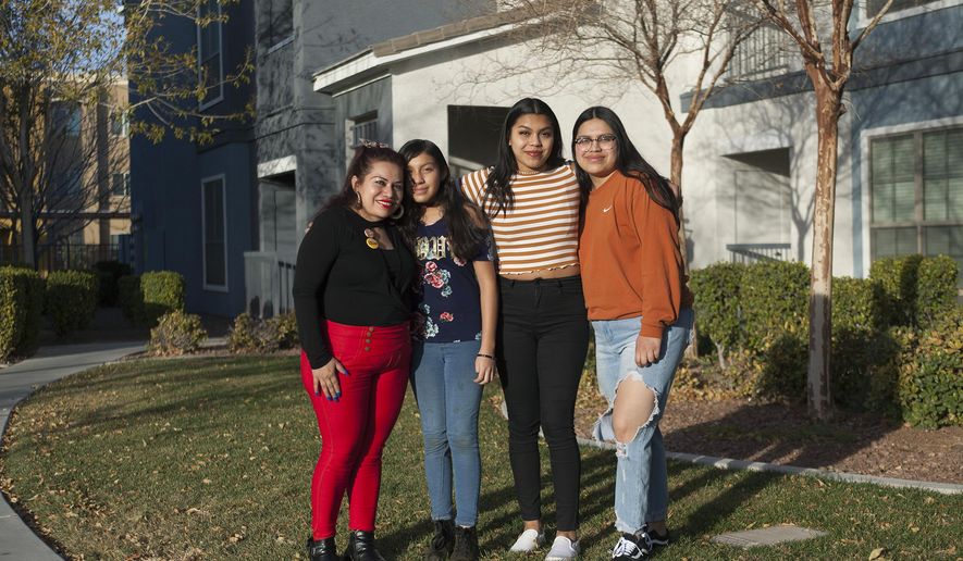 In this Friday, Dec. 22, 2017 photo, Ericka Lopez, from left, and her daughters Emily Garcia, 12, Anna Ramos Lopez, 16, and Glenda Ramos Lopez, 20,stand in front of their home in Las Vegas. Lopez fears her family will be split in half in future immigration decisions. Some are citizens and some are under temporary protected status.  (Rachel Aston/Las Vegas Review-Journal via AP)