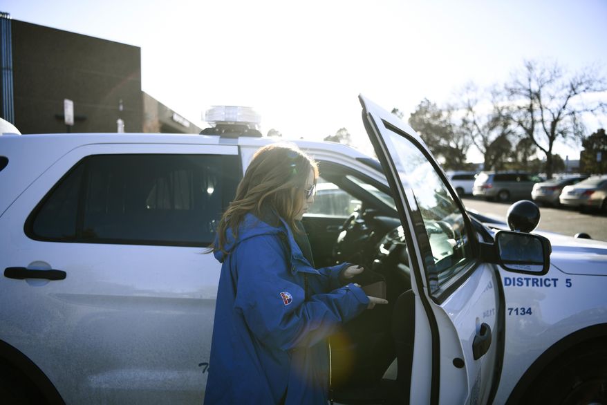 In a Dec. 21, 2017 photo, Samantha Rabins, of Mental Health Center of Denver, prepares to roll out with an officer at Denver Police District 5 in Denver. Faced with escalating arrests in Colorado, the state is prodding police departments to try new diversion programs for those with mental illnesses or drug addictions. Instead of just arresting troubled individuals, police in Boulder and Denver now are having mental health clinicians ride along when police respond to emergency 911 calls. (Aaron Ontiveroz//The Denver Post via AP)