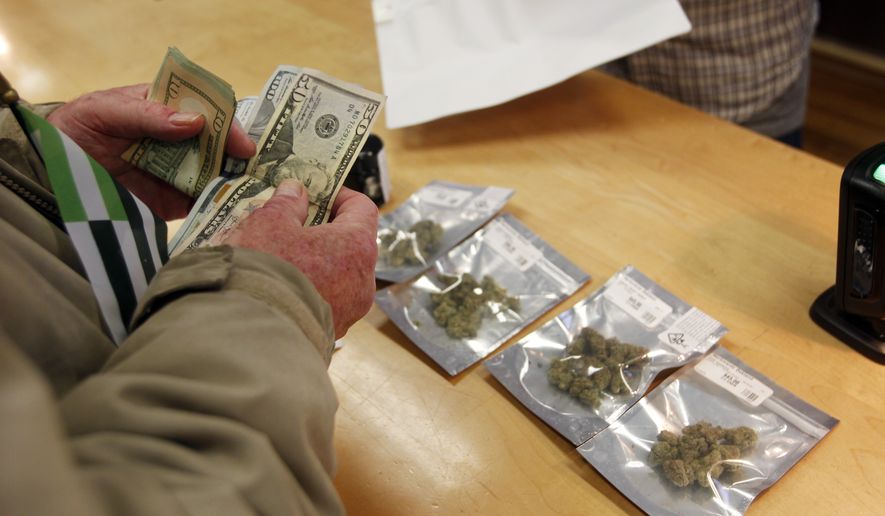 In this Monday, Jan. 1, 2018 file photo, a customer purchases marijuana at the Harborside marijuana dispensary in Oakland, Calif., on the first day that recreational marijuana was sold legally in California. (AP Photo/Mathew Sumner)