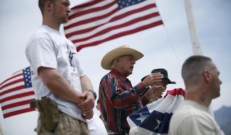 FILE - In this April 18, 2014, file photo, flanked by armed supporters, rancher Cliven Bundy speaks at a protest camp near Bunkerville, Nev. A U.S. judge who declared a mistrial two weeks ago could on Monday, Jan. 8, 2018, kill the much-watched criminal prosecution of the Nevada rancher accused of leading an armed uprising against federal authorities in April 2014. Chief U.S. District Judge Gloria Navarro&#39;s decision in Las Vegas is sure to echo among states&#39; rights advocates in Western states where the federal government controls vast expanses that some people want to remain unused and others want open to grazing, mining and oil and gas drilling. (John Locher/Las Vegas Review-Journal via AP, File) **FILE**
