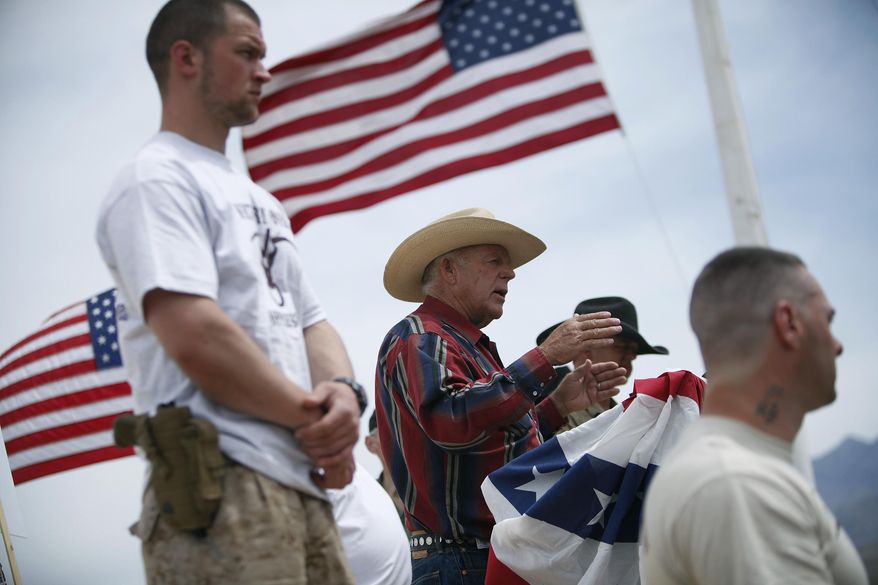FILE - In this April 18, 2014, file photo, flanked by armed supporters, rancher Cliven Bundy speaks at a protest camp near Bunkerville, Nev. A U.S. judge who declared a mistrial two weeks ago could on Monday, Jan. 8, 2018, kill the much-watched criminal prosecution of the Nevada rancher accused of leading an armed uprising against federal authorities in April 2014. Chief U.S. District Judge Gloria Navarro's decision in Las Vegas is sure to echo among states' rights advocates in Western states where the federal government controls vast expanses that some people want to remain unused and others want open to grazing, mining and oil and gas drilling. (John Locher/Las Vegas Review-Journal via AP, File) **FILE**