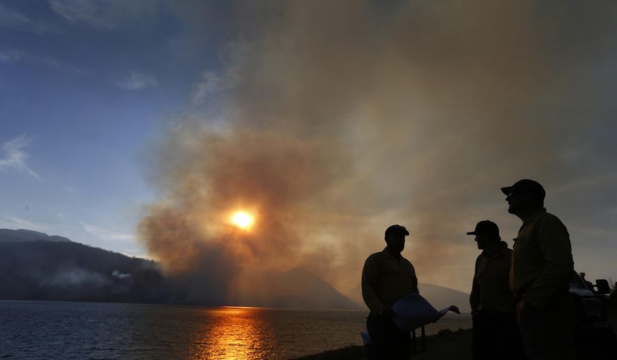 FILE - In this Aug. 26, 2016, file photo, firefighters just in from Pennsylvania get briefed on a wildfire as it burns off the shore of Jackson Lake in Grand Teton National Park, Wyo. Wyoming recorded an above-average number of wildfires in 2017 but the state escaped the large conflagrations that plagued other western states, according to state forester Bill Crapser. (AP Photo/Brennan Linsley, File)