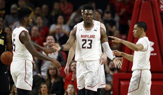 Maryland forward Bruno Fernando, of Angola, (23) high-fives teammates Dion Wiley, left, and Anthony Cowan after a play in the first half of an NCAA college basketball game against Iowa in College Park, Md., Sunday, Jan. 7, 2018. (AP Photo/Patrick Semansky)