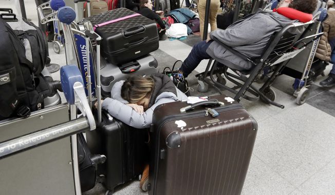 Avianca passengers rest while waiting for their flight at New York&#x27;s John F. Kennedy Airport Terminal 4, Monday, Jan. 8, 2018. The Port Authority of New York and New Jersey said Monday it will investigate the water pipe break that added to the weather-related delays at Kennedy Airport and will &amp;quot;hold all responsible parties accountable.&amp;quot; (AP Photo/Richard Drew)
