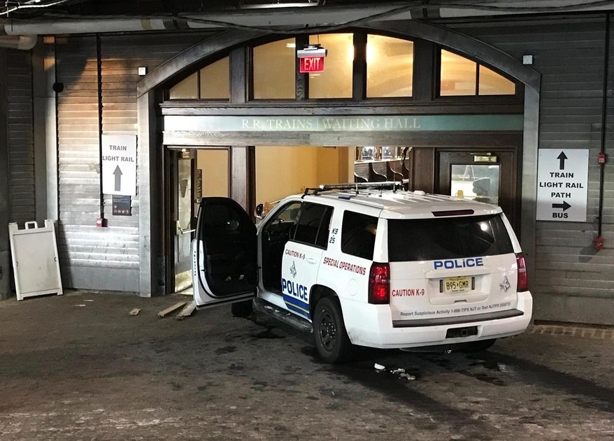 A police K-9 SUV sits on the scene after a person crashed it into the doors of the waiting room at the Hoboken, N.J., rail terminal Monday, Jan. 8, 2018. (Dan Strzelec via AP)