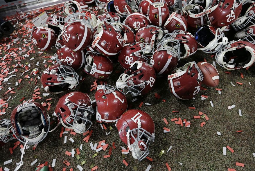 Alabama helmets lay with confetti after overtime of the NCAA college football playoff championship game against Georgia Monday, Jan. 8, 2018, in Atlanta. Alabama won 26-23. (AP Photo/David J. Phillip)