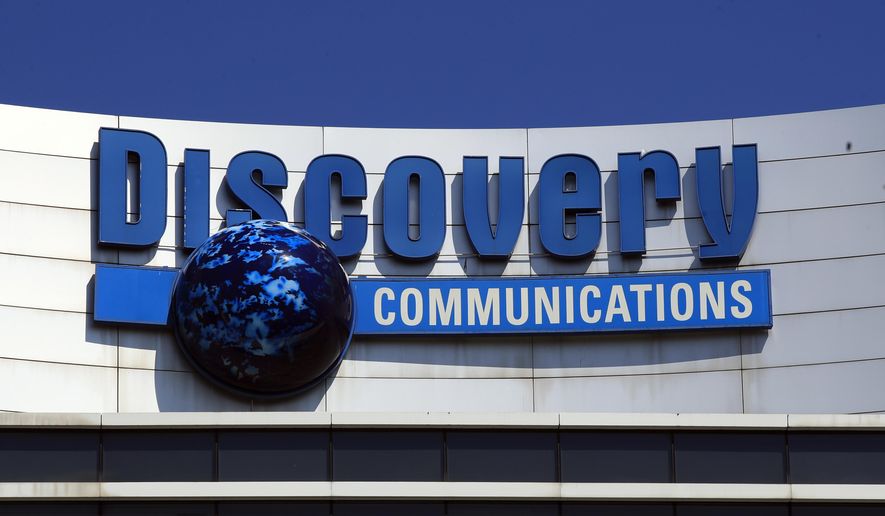 FILE - In this Monday, July 31, 2017, file photo, the Discovery Communications logo sits atop its headquarters in Silver Spring, Md. Discovery Communications, the company that operates the Discovery Channel, Animal Planet, TLC and other popular cable channels, announced Tuesday, Jan. 9, 2018, that it plans to relocate its global headquarters from Maryland to New York City, in 2019. (AP Photo/Manuel Balce Ceneta, File)