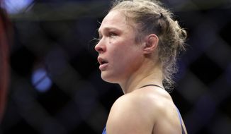 FILE - In this Dec. 30, 2016, file photo Ronda Rousey stands in the cage after Amanda Nunes forced a stoppage in the first round of their women&#39;s bantamweight championship mixed martial arts bout at UFC 207 in Las Vegas. Rousey&#39;s next fight could come in a WWE ring. WWE executive Paul Levesque, better known as wrestling superstar Triple H, had dinner with Rousey in Los Angeles on Tuesday night, Jan. 8, again fueling speculation that UFC&#39;s biggest female star could leave the octagon for a career in sports entertainment. &amp;quot;We are talking to Ronda, as we&#39;ve been for a while,&amp;quot; Levesque told The Associated Press by phone on Wednesday. &amp;quot;She has a lot of things going on. We have a lot of things going on. But we have a great relationship with her, a very friendly standpoint for a long period of time now. It was great to catch up with her.&amp;quot; (AP Photo/John Locher, File)