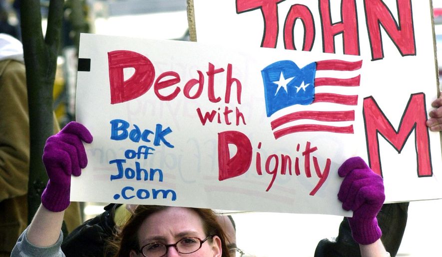 Stacey Richter holds a sign outside a federal courthouse in Portland, Ore., as a hearing begins to decide the fate of Oregon&#39;s physician-assisted suicide law. Voters approved the aid-in-dying proposal in 1994 and it then survived a repeal effort. The law that took effect Oct. 27, 1997 made Oregon the first state to make it legal for a doctor to prescribe a life-ending drug to a terminally ill patient of sound mind who makes the request. (AP Photo/Don Ryan, File) **FILE**
