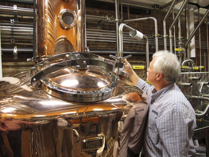 FILE - In this Wednesday Nov. 13, 2013, file photo, Charlie Downs, the artisanal craft distiller at a new Heaven Hill Distilleries tourism attraction in downtown Louisville, Ky., checks gauges on a still that will produce small batches of whiskey. In an effort to woo Amazon's second headquarters to their area, Louisville is playing up its role as the gateway to Kentucky bourbon country. However, the city isn't saying exactly what incentives they are offering to Amazon as enticement to build there. (AP Photo/Bruce Schreiner, File)