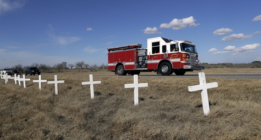 Ryland Ward, who was shot during a Nov. 5 church shooting, looks out the passenger window as he passes a memorial of crosses as he returns home after his release from the hospital while riding in the cab of a firetruck, Thursday, Jan. 11, 2018, in Sutherland Springs, Texas. Ward, 6, was shot several times and was the last victim still hospitalized following the church massacre in South Texas. (AP Photo/Eric Gay)