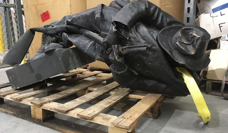 FILE - In this Aug. 15, 2017, file photo, a damaged Confederate statue lies on a pallet in a warehouse in Durham, N.C. The Durham County district attorney said in an email Thursday, Jan. 11, 2018, that he plans to drop felony charges against eight protesters accused of toppling the statue and try them only on misdemeanor charges. (AP Photo/Allen Breed, File)