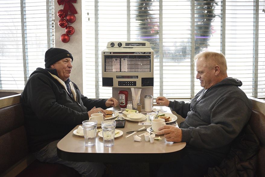 Nick Del Geurcio from Cedar Grove, N.J., and Tom Scorso from Belleville brave the storm to eat at North Arlington Diner on Thursday, Jan. 4, 2018 in North Arlington, N.J. In Bergen County, people hunkered down at the Arlington Diner in North Arlington. A sign on the door asked patrons to knock the snow from their boots before coming in. The owner put it there after firefighters, fresh from digging out hydrants, tracked in snow and left the marble floor slick during the lunchtime rush, said Karen Smith, a server. (Anne-Marie Caruso/The Record via AP)