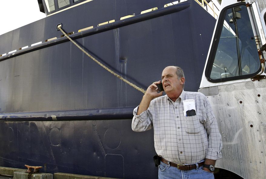 FILE - In this Oct. 14, 2014, file photo, Carlos Rafael talks on the phone at Homer's Wharf near his herring boat F/V Voyager in New Bedford, Mass. The federal government is trying to keep Rafael, known as the Codfather, out of the seafood business. Rafael was sentenced in 2017 to nearly four years in prison after pleading guilty to evading fishing quotas and smuggling money to Portugal. (John Sladewski/Standard Times via AP, File)