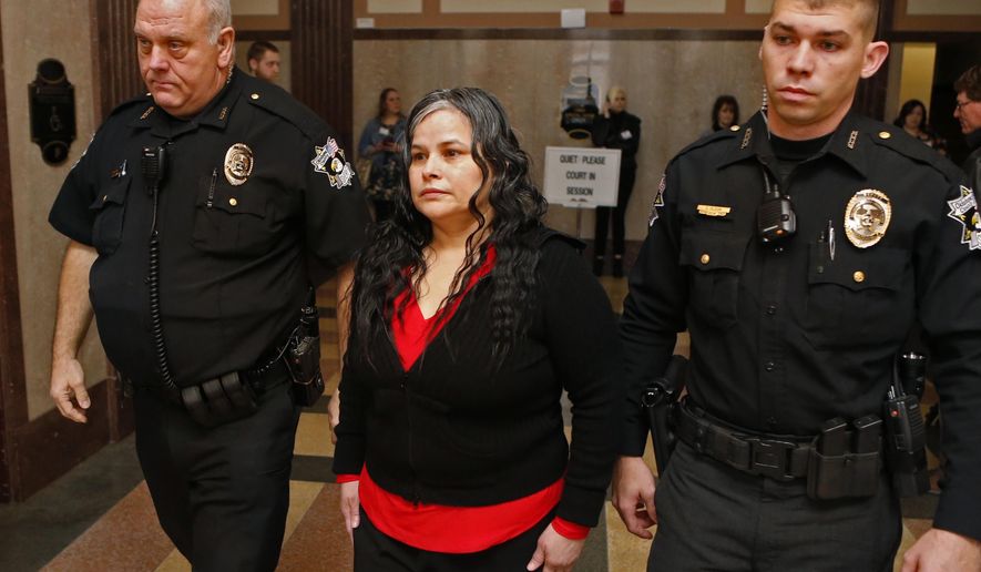 FILE - In this Jan. 9, 2018, file photo, Juanita Gomez is led into Oklahoma County District Court in Oklahoma City. A jury on Thursday, Jan. 11, 2018, convicted Gomez of killing her 33-year-old daughter in 2016 by forcing a crucifix and medallion down her throat because she believed the woman was possessed by the devil. (Steve Sisney/The Oklahoman via AP, File)