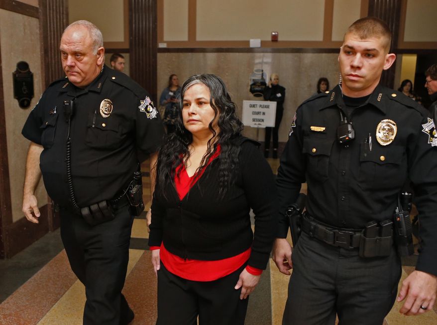 FILE - In this Jan. 9, 2018, file photo, Juanita Gomez is led into Oklahoma County District Court in Oklahoma City. A jury on Thursday, Jan. 11, 2018, convicted Gomez of killing her 33-year-old daughter in 2016 by forcing a crucifix and medallion down her throat because she believed the woman was possessed by the devil. (Steve Sisney/The Oklahoman via AP, File)