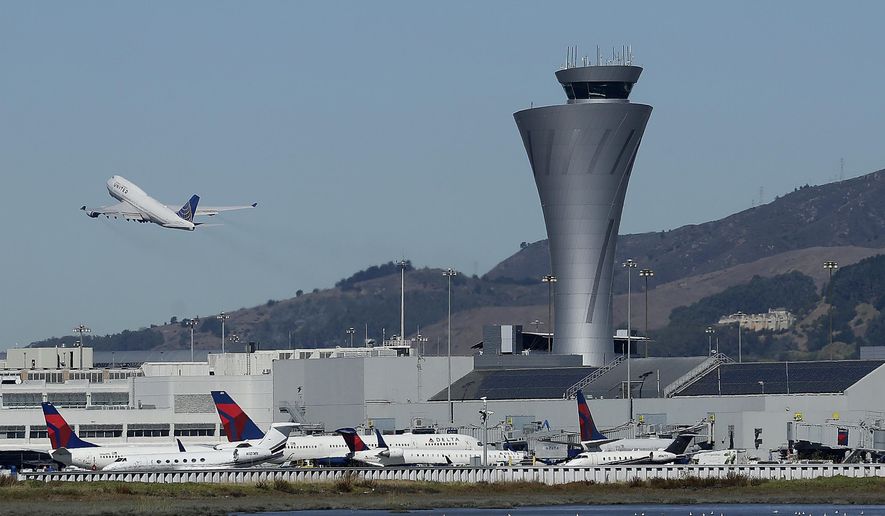 FILE--In this Oct. 24, 2017, file photo, the air traffic control tower is in sight as a plane takes off from San Francisco International Airport in San Francisco. An Aeromexico passenger jet was ordered to abort a landing at San Francisco International Airport Tuesday, Jan. 9, 2018, as it descended toward a runway occupied by another commercial jet, the third close call at the busy airport in six months. (AP Photo/Jeff Chiu, file)