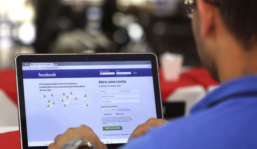 In this Thursday, Jan. 4, 2018, file photo, a man demonstrates how he enters his Facebook page as he works on his computer at a restaurant in Brasilia, Brazil. (AP Photo/Eraldo Peres, File)