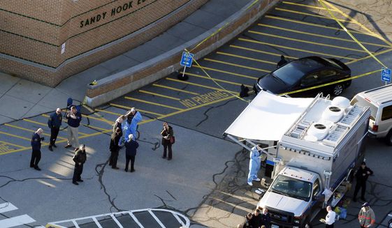 In this Dec. 14, 2012, file photo, officials stand outside of Sandy Hook Elementary School after a shooting in Newtown, Conn. Connecticut State Police are planning to release a report assessing the agency’s response to the 2012 massacre at Sandy Hook Elementary School. (AP Photo/Julio Cortez, File) **FILE**