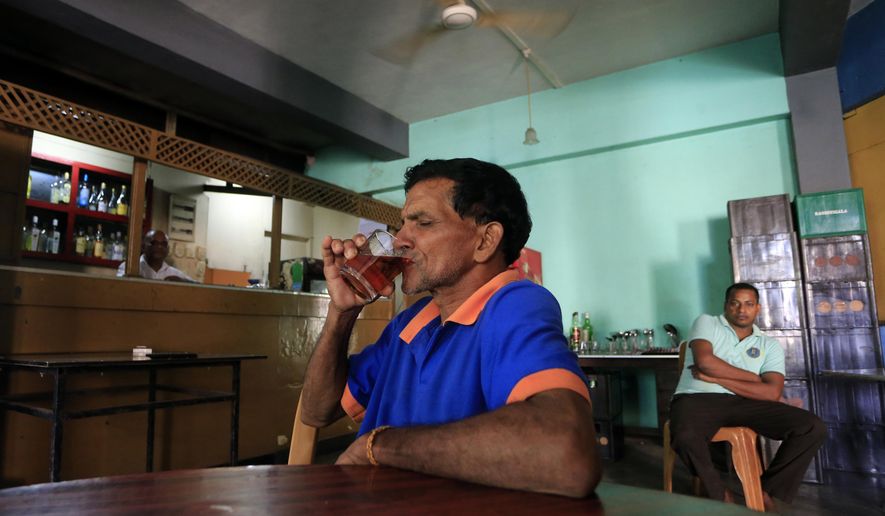 A Sri Lankan man sips an alcoholic drink at a bar in Colombo, Sri Lanka, Friday, Jan. 12, 2018. Sri Lanka has revoked a 38-year ban on selling alcohol to women and employing them in places where the brews are produced and sold. (AP Photo/Eranga Jayawardena)