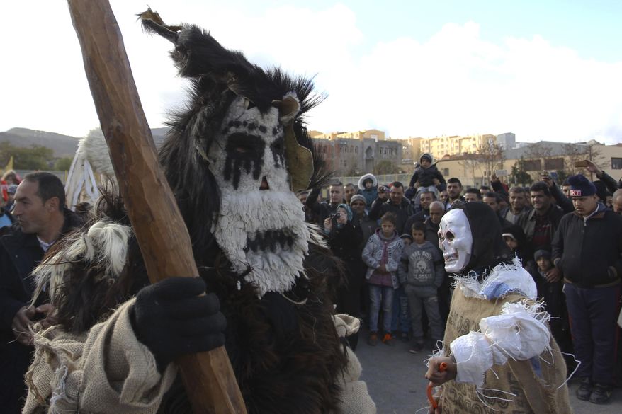 Disguised men perform in the village of Beni Snous, south of Tlemcen, Algeria, Thursday, Dec.11, 2018. Algerians in the Beni Snous region dress in elaborate animal-hide costumes and parade through town with traditional instruments as part of the Ayred festival. (AP Photo/Anis Belghoul)