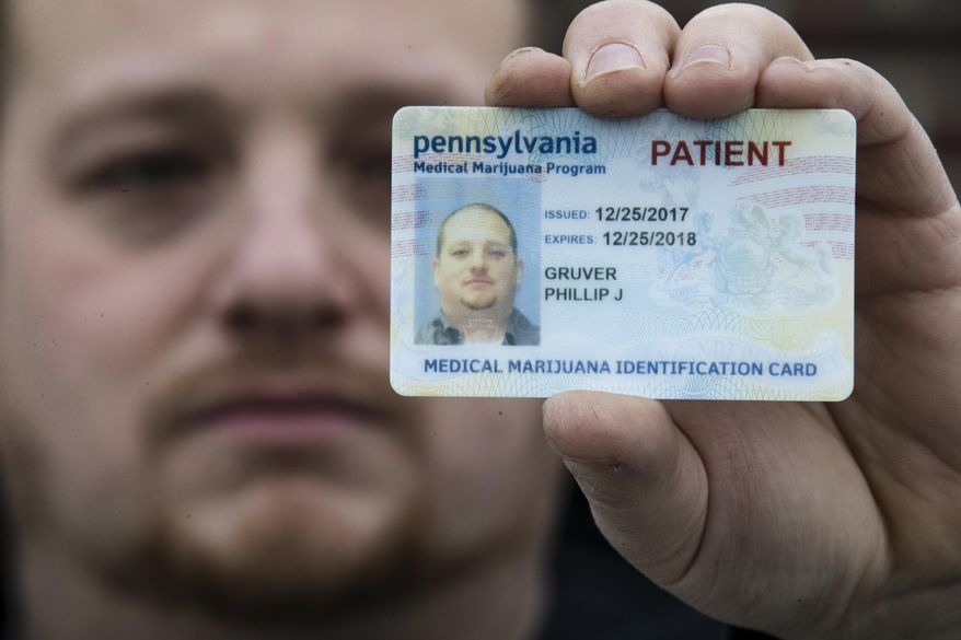 In this Wednesday, Jan. 10, 2018 photo Phil Gruver poses for a photograph with his Pennsylvania with his medical marijuana card in Emmaus, Pa. As gun-loving Pennsylvania becomes the latest state to operate a medical marijuana program, with the first dispensary on track to begin sales next month, authorities are warning patients that federal law bars marijuana users from having guns or ammunition. Gruver is weighing what to do with his .22-caliber rifle and a handgun he keeps for home defense. (AP Photo/Matt Rourke)