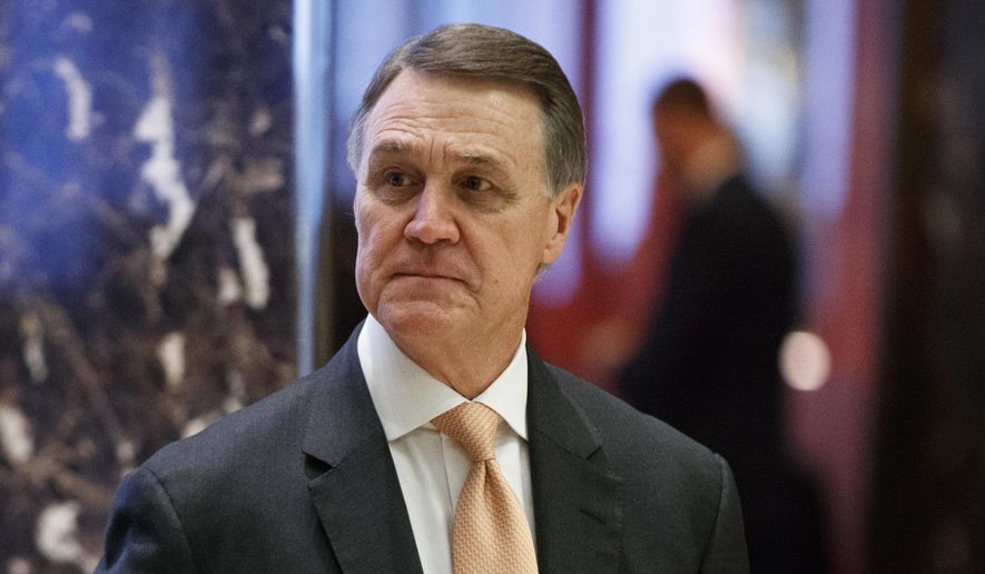 In this Dec. 2, 2016, file photo, Sen. David Perdue, R-Ga., walks to the elevator for a meeting with President-elect Donald Trump at Trump Tower, in New York. (AP Photo/Evan Vucci, File)